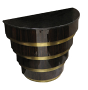 A modern demilune console table in high-gloss ebony and brass stepped base with stone top.
